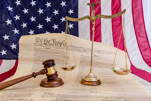 legal scale court gavel and us constitution on American flag